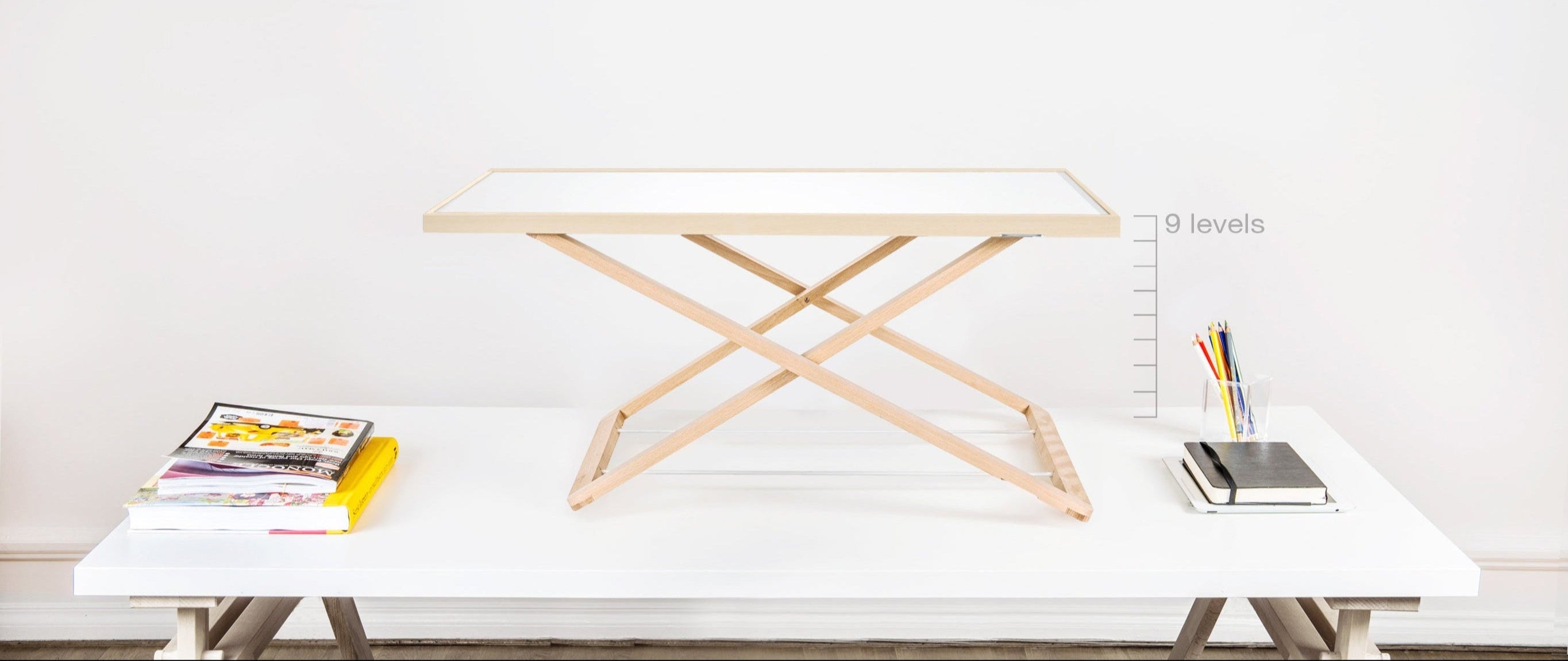 Freedesk Desk Riser displayed on a desk, showcasing its adjustable 9-level height settings for an ergonomic workspace.