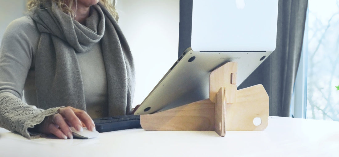Woman working with a laptop using a Freedesk Laptop Stand.