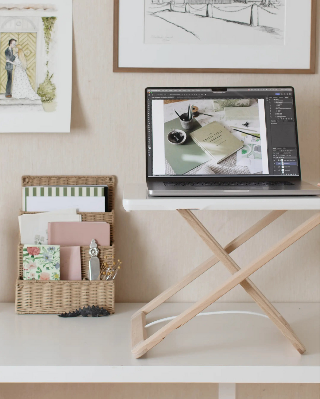 Freedesk Desk Riser Original Compact at a desk with vintage wall art and a laptop