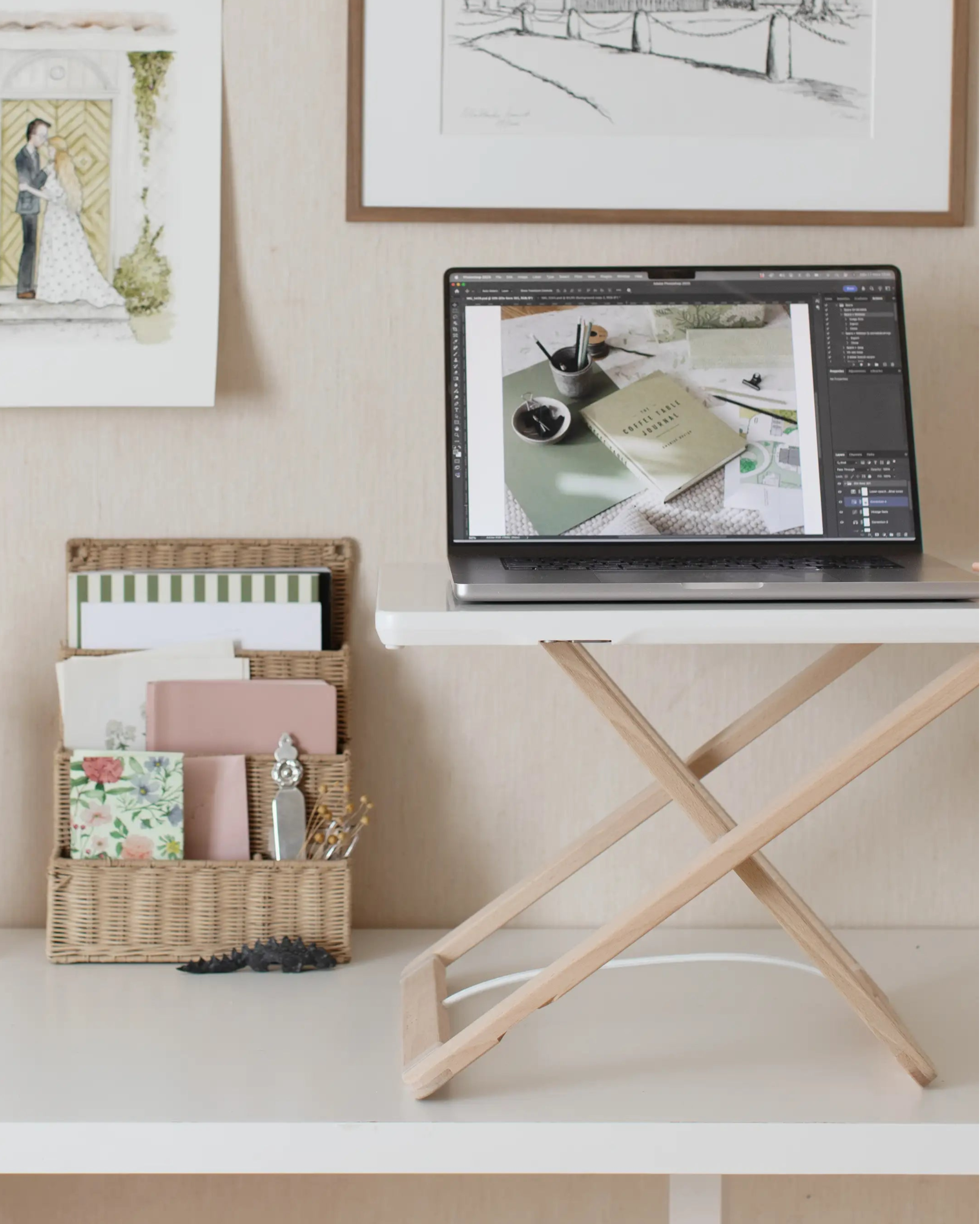 Freedesk Desk Riser Original Compact at a desk with vintage wall art and a laptop