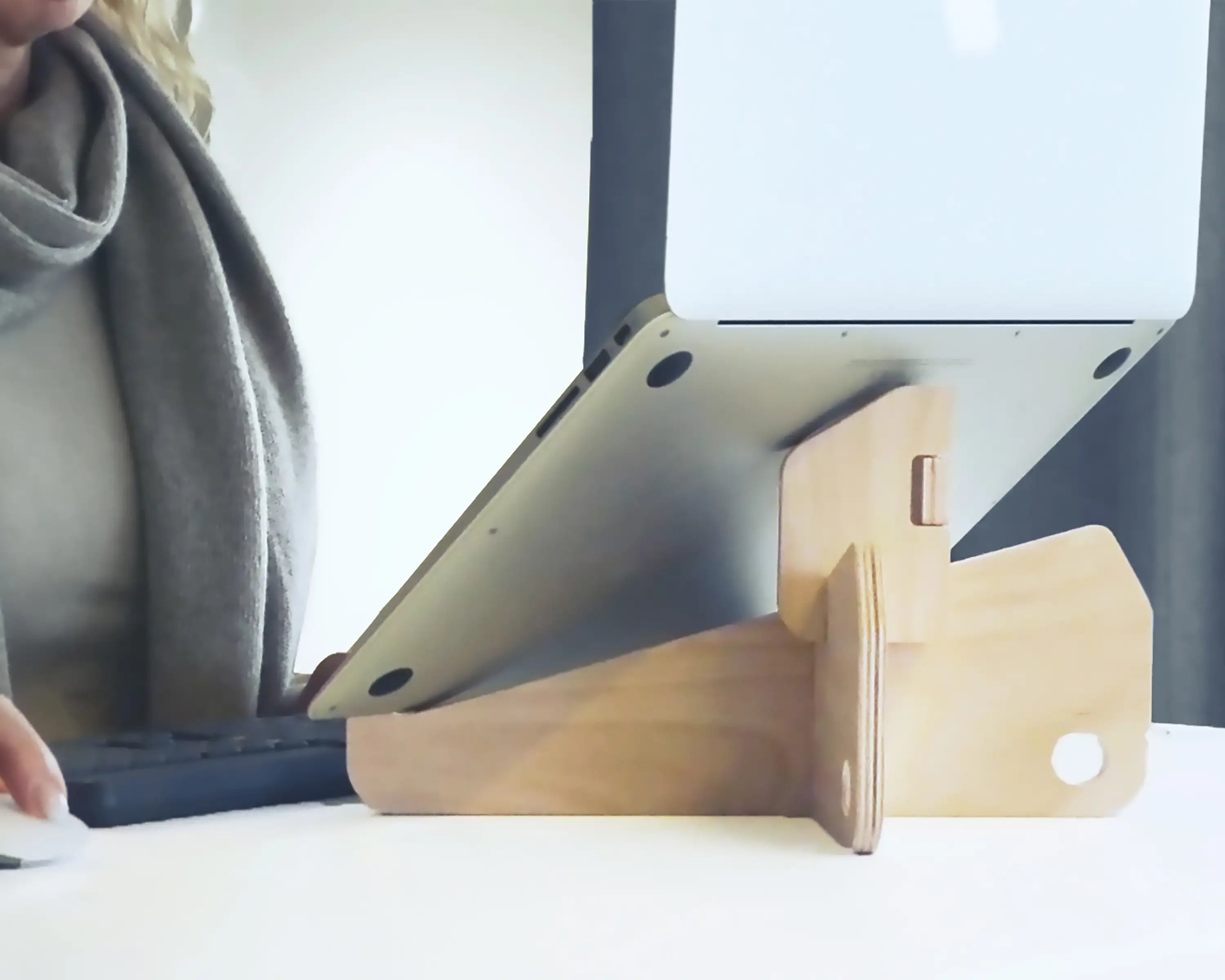 Freedesk Laptop Stand made of natural wood, elevating a laptop for an ergonomic workspace setup with an external keyboard and mouse.